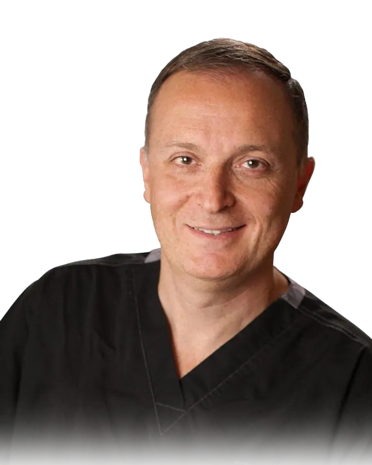 Portrait of Dr. Igor Kaplansky smiling, in dark scrubs