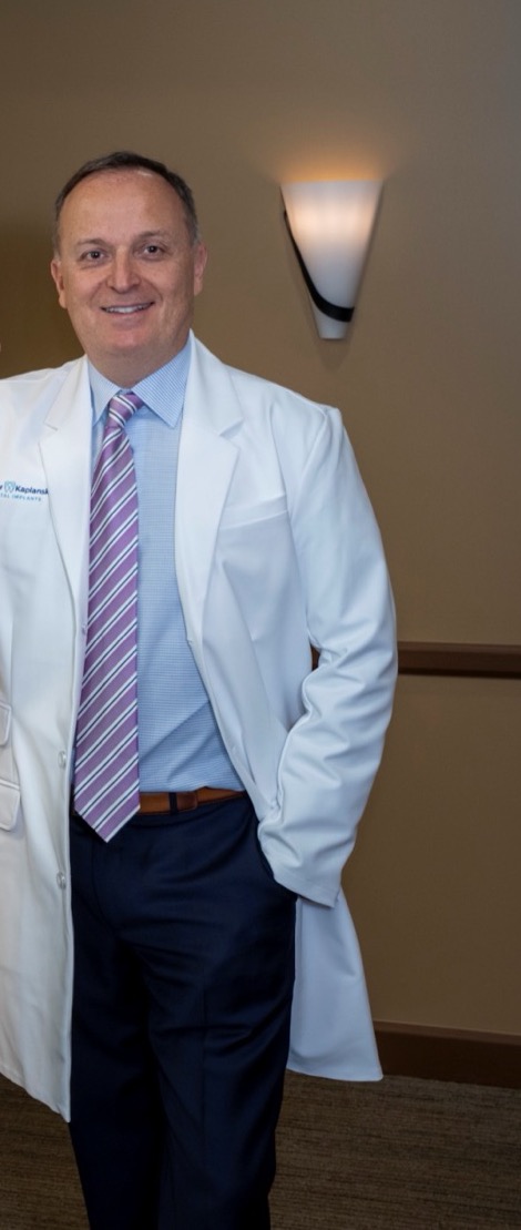 Dr. Igor Kaplansky in a white coat, leaning against a glass wall